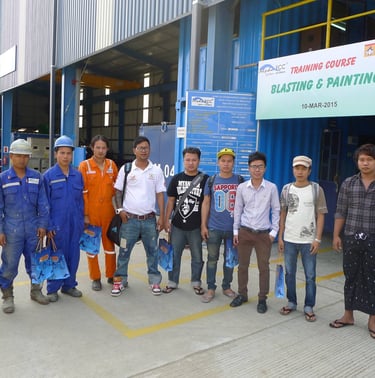 Industrial workers posing for a photo at a Jotun blasting and painting training course facility.