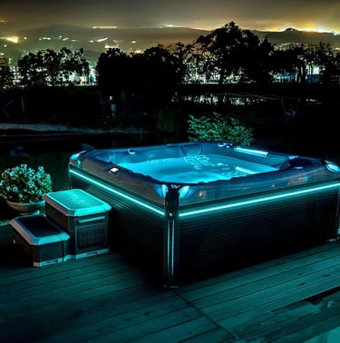 Luxury outdoor hot tub with glowing blue LED lighting on a wooden deck at night.