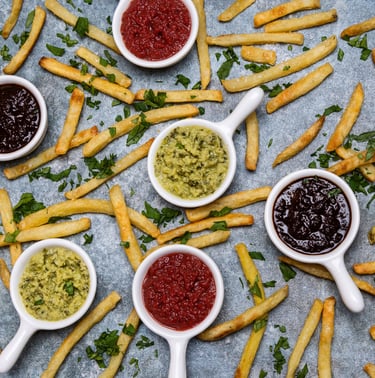 Sustainable plant-based sauces displayed in small white dishes with potato chips surrounding
