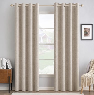 Beige grommet blackout curtains with a linen texture hanging in a bright modern living room.