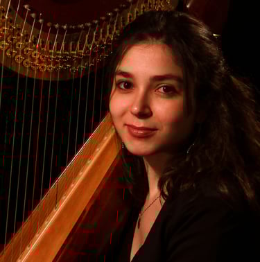 Headshot of a female harp player posing in front of her instrument