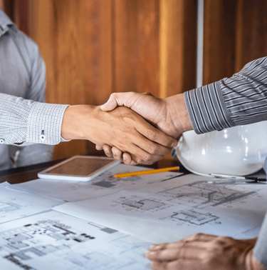 Apretón de manos sobre planos: contacto para renders 3D y visualización arquitectónica.