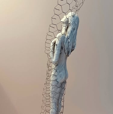 A standing female figure, leaning back and relaxing, surrounded by a wire netting enclosure