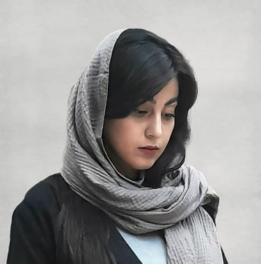 Portrait of a VISUALISE team member wearing a light-colored headscarf and dark outfit, with a plain, neutral background.
