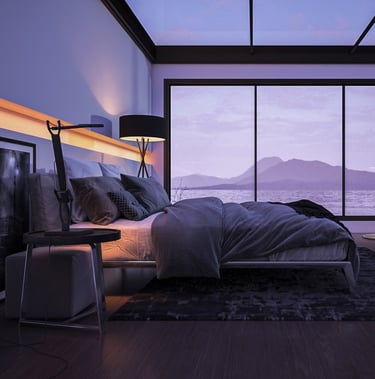 Modern bedroom with large bed, floor-to-ceiling windows, and view of lake and mountains.