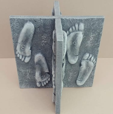Two intersecting relief sculptures forming an X shape, and depicting three dimensional footprints.