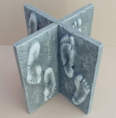 Two intersecting relief sculptures forming an X shape, and depicting three dimensional footprints.