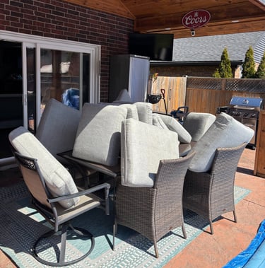 Outdoor patio cushions stacked for professional upholstery cleaning and drying in the sun.