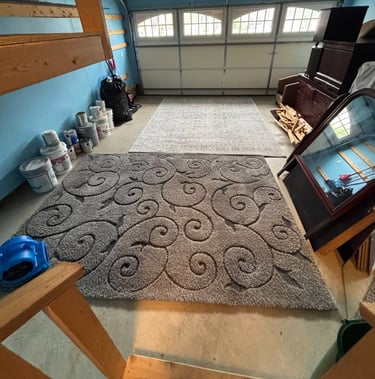 Two cleaned area rugs drying side-by-side in a garage.