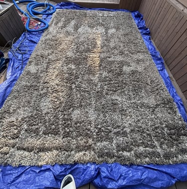 Gray rug on patio during deep cleaning. Outdoor rug cleaning for your convenience.