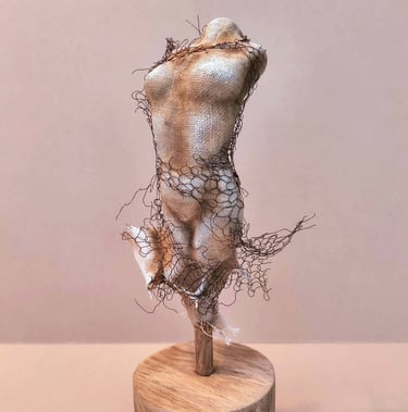 Female torso, clothed in tight fitting fabric, wrapped in torn copper wire netting