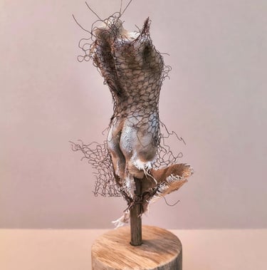 Female torso, clothed in tight fitting fabric, wrapped in torn copper wire netting