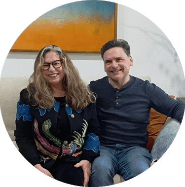 a man and woman sitting on a couch smiling