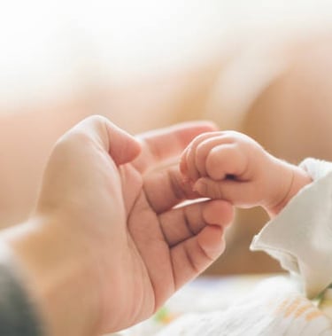Main d'un bébé et de sa maman