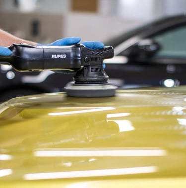 a person in gloves and polishing a car