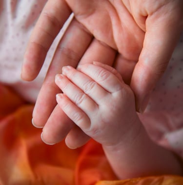 Mother holding a newborn baby's hand