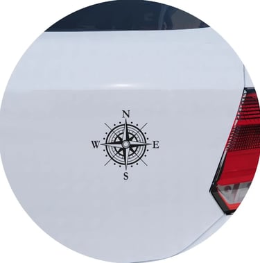 Black nautical compass rose vinyl decal applied to the rear of a white car.