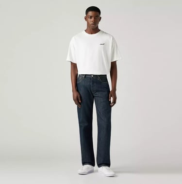 Male model wearing Levi’s 501 Jeans in dark indigo, paired with a white t-shirt and sneakers.