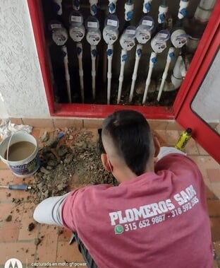 Plomero reparando fuga en medidores de agua potable