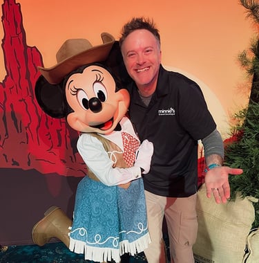 Minnie's Travel Boutique co-owner Chris Breedlove pictured with Minnie Mouse at The Disneyland® Hotel.