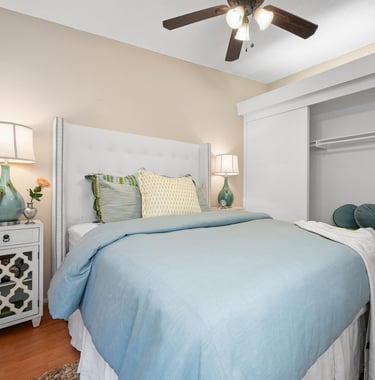 a bedroom with a ceiling fan, luxurios bed, pillows and nice bedding