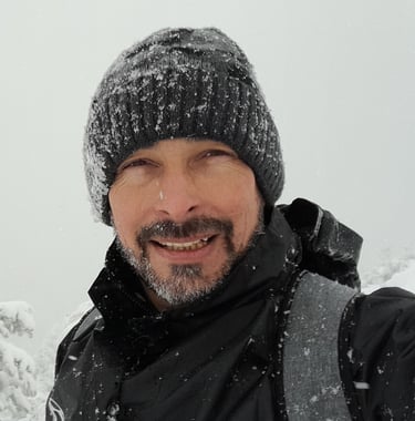 a man in a black jacket and a hat on a snowy day