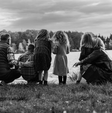 a family of four children sitting on the grass
