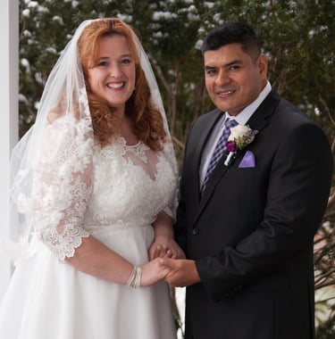 a man and woman in wedding attire standing in front of a white house