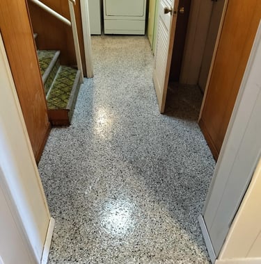 Seamless epoxy floor installed in a residential hallway and laundry room, featuring a durable flake 