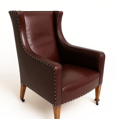 Brown leather high-back vintage armchair with wooden legs