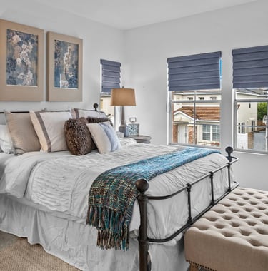 An after staging picture of a luxurious bedroom with a bed and a chair