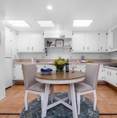 after staging: a kitchen with a table and chairs in the middle of the room