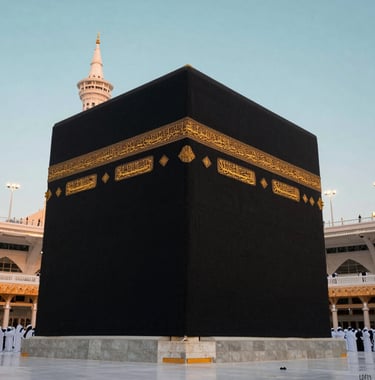 A high-quality, dignified photograph of the Kaaba in Makkah at sunrise. The golden calligraphy on the black cloth contrasts with the pale aqua morning sky. The atmosphere is quiet and reverent. International / Global Muslim pilgrims visible in the distance.