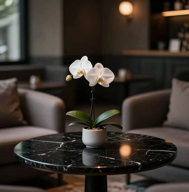 Interior photography of a dimly lit private lounge featuring a sleek black marble table and a single white orchid, soft focus background, quiet luxury mood, North American / International editorial style.