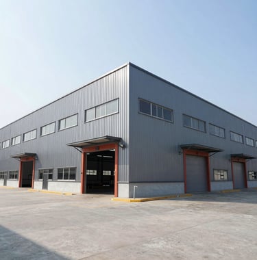 Photography of a large modern warehouse facility in a Southeast Asian industrial park, showcasing clean engineering, grey metal cladding, and terracotta red accents under a bright, clear sky.