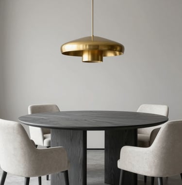 A minimalist dining room featuring a charcoal gray oak table, soft off-white chairs, and a muted gold sculptural light fixture hanging above. Clean, professional composition. International / High-end.