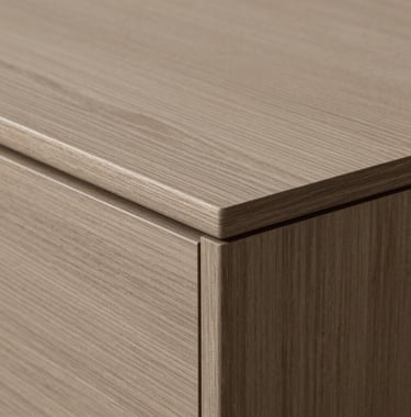 A detail shot of custom-made furniture featuring warm taupe wood and minimalist joinery, emphasizing the studio's focus on craftsmanship.