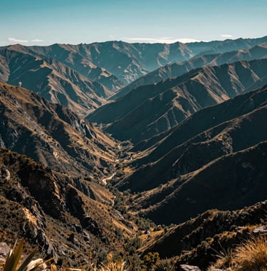 A wide landscape shot of the mountain ranges surrounding Hierve el Agua. The scene is bathed in a deep teal and golden light, showcasing the high-altitude Mexican terrain and the serene atmosphere of the San Lorenzo Albarradas region.