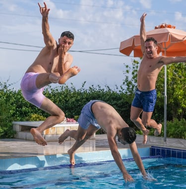 grupo de amigos se divertindo ao pular na piscina durante momento de lazer ao ar livre