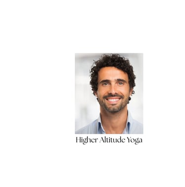 Smiling male yoga student at Higher Altitude Yoga sudio with dark curly hair and a beard.