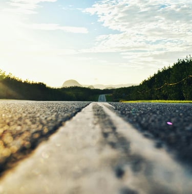 A Long road with text reading "Road Trips" linking to a page with road trips from Texas.
