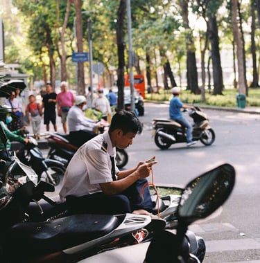 Vietnamese street security playing video game on the phone