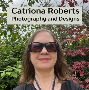 Image of a woman standing infront of shrubs.