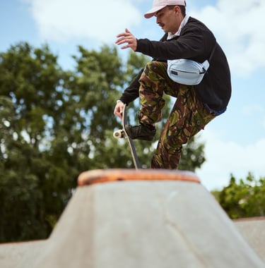 Fashion Photography - a man in camouflage pants and a baseball cap, skateboarding on a ramp