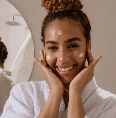 Woman in bathroom appyling azeliac acid serum to her face morning skincare routine