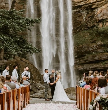 bride and groom reciting vows in front of a waterfall destination wedding