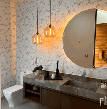  Baño moderno con lavabo de mármol, espejo circular e iluminación cálida KARÄNA