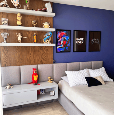 Recámara infantil con pared azul, figuras decorativas y cabecera gris | KARÄNA