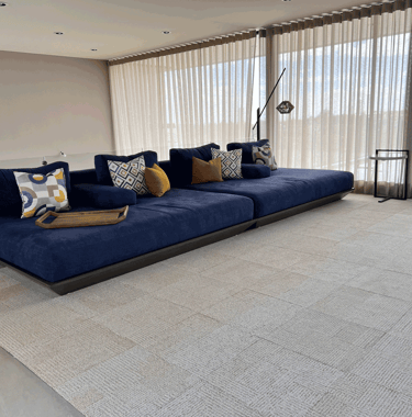 Sala minimalista con sofá azul y cojines decorativos | KARÄNA
