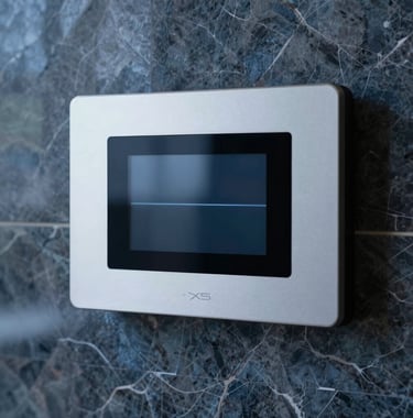 Close-up photography of a sophisticated steam control interface mounted on a dark steel blue marble wall. The digital display is minimalist and elegant, reflecting high-end North American smart-home technology and premium industrial design.